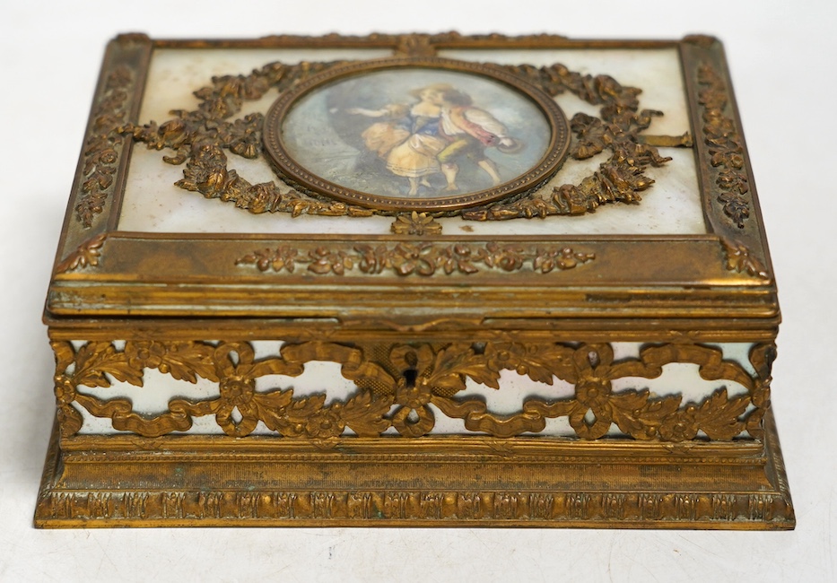 A French mother of pearl and gilt metal trinket box inset with a hand painted panel of two figures, 15cm wide. Condition - fair, feet present (one broken)